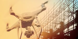 Drone overlaid in foreground of image, with building construction in the background.